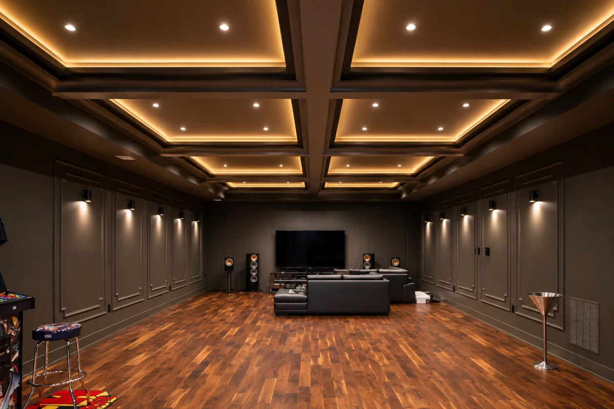 Finished basement media room with coffered ceiling, cove lighting, and surround-sound wiring